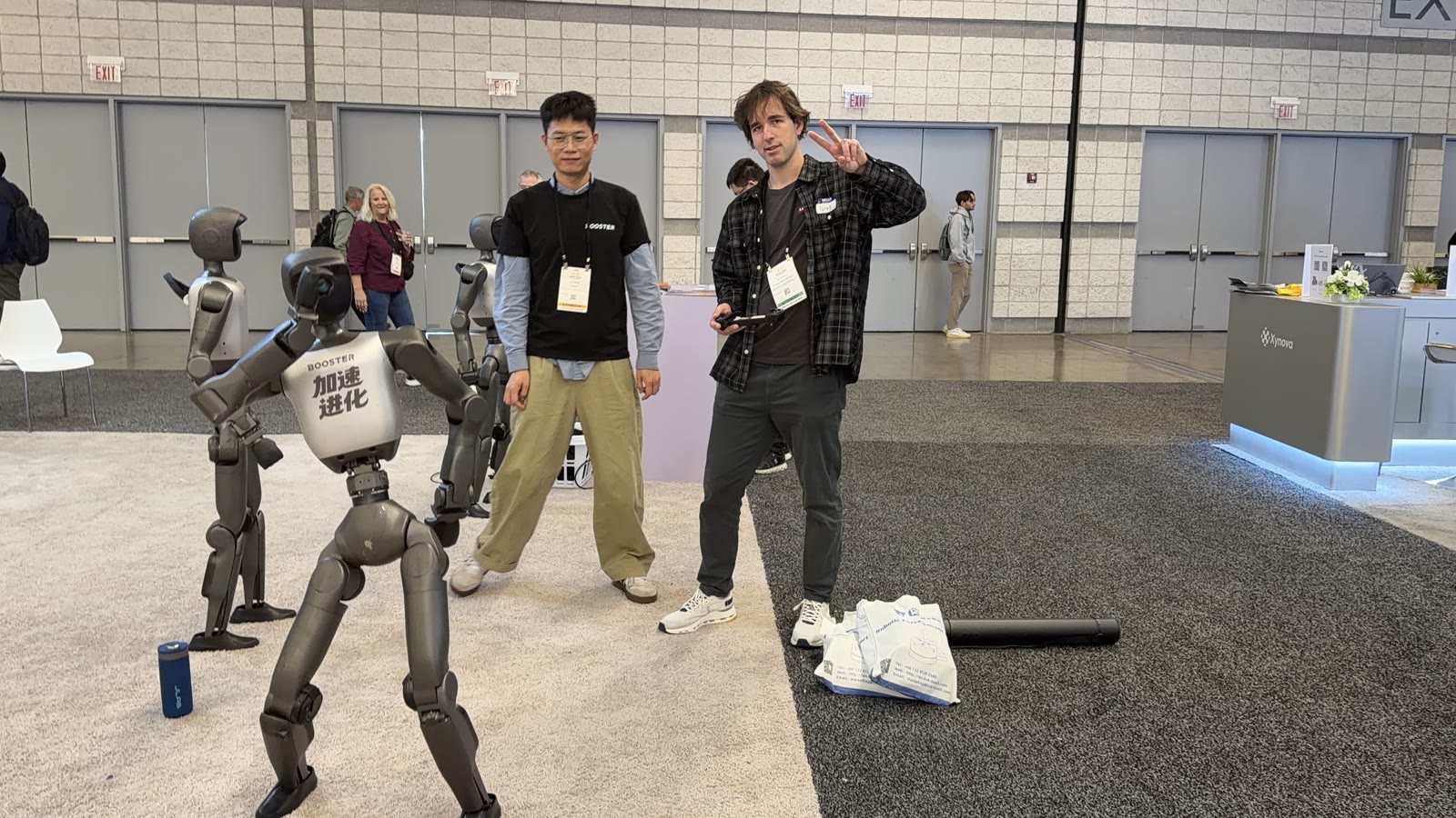 At the Booster Robotics booth at IROS 2026 with two Booster robots